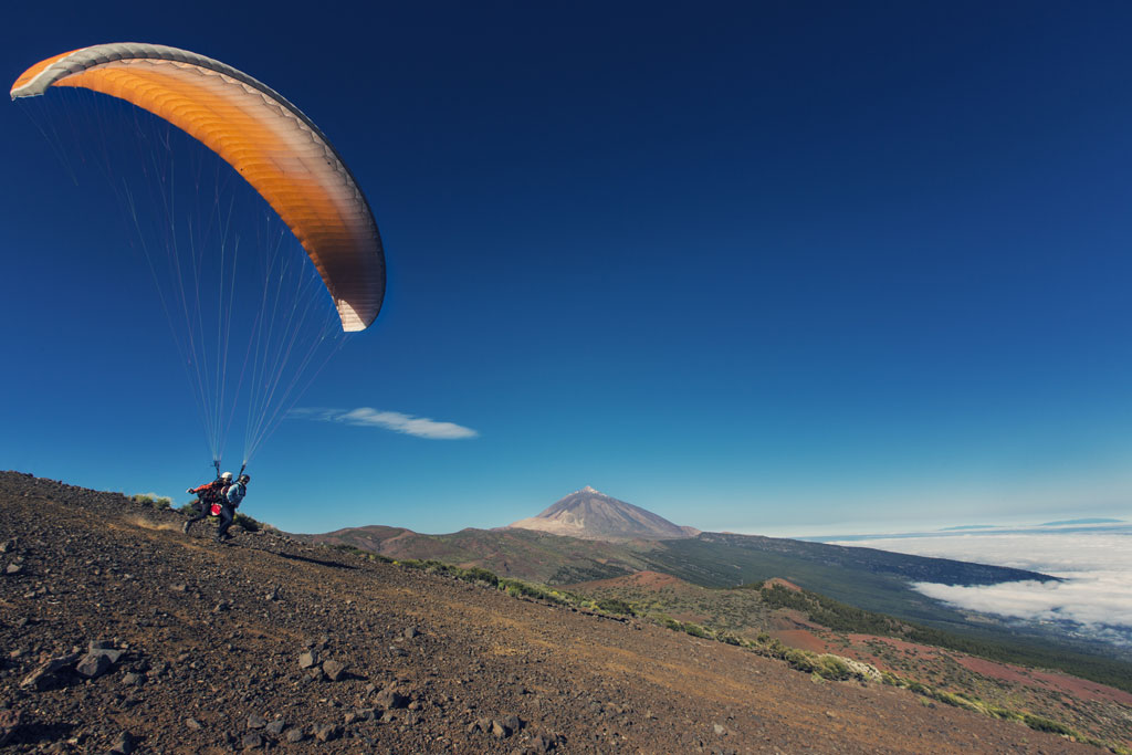 Paraglider die opstijgt vanaf een heuvel nabij de berg Teide op Tenerife.