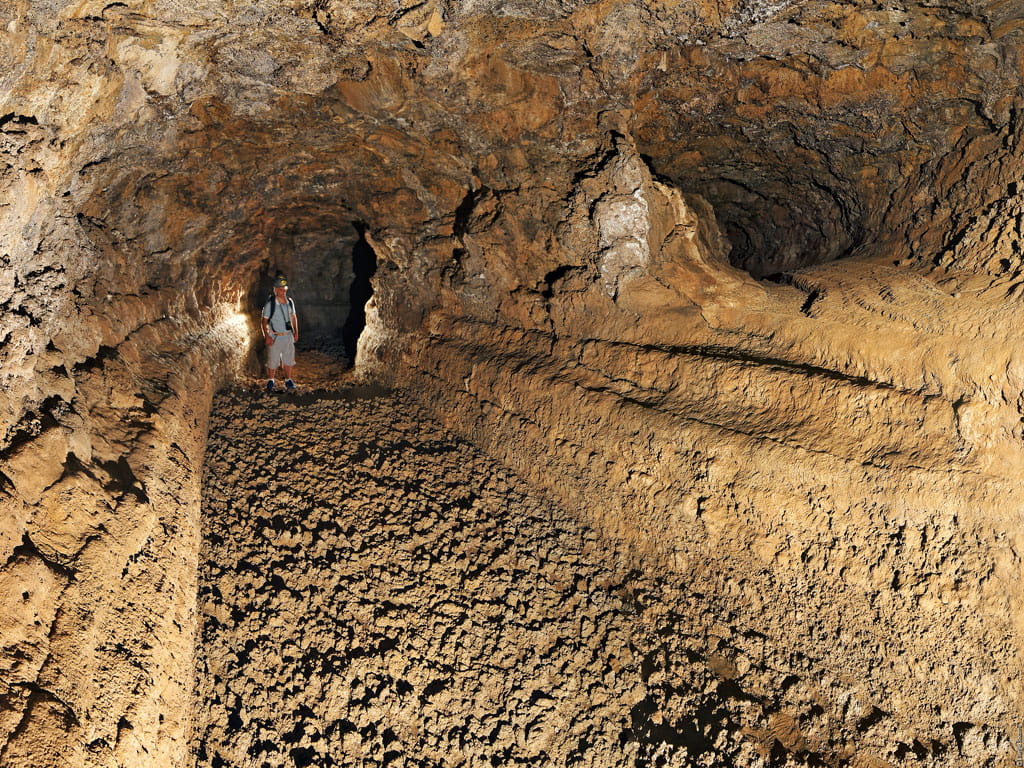 Persoon die een vulkanische grot op Tenerife verkent.