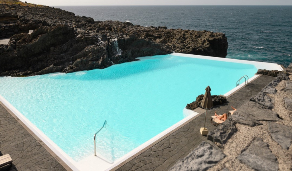 Natuurlijk zwembad omringd door rotsen en zeezicht op Tenerife.