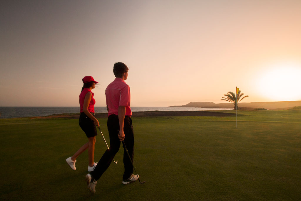 Mensen die bij zonsondergang golf spelen aan de kust van Tenerife.