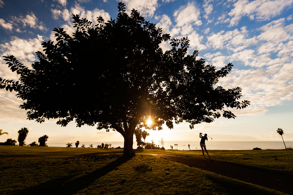 Iemand die bij zonsondergang golf speelt op een baan op Tenerife.