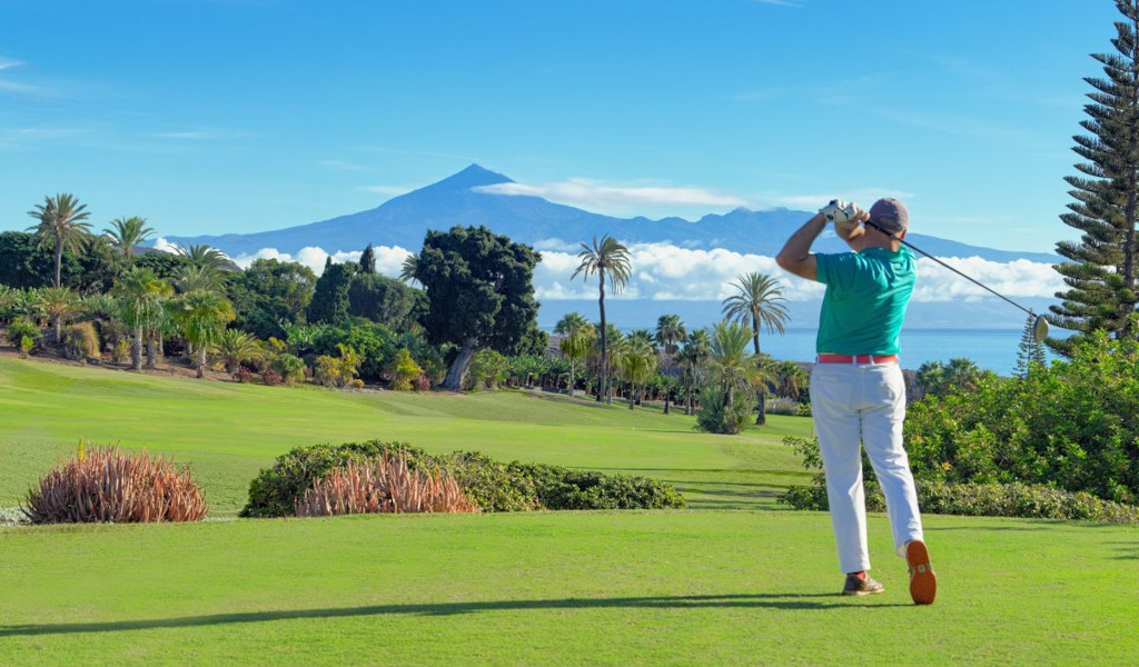Golfer in actie met de berg Teide op de achtergrond op Tenerife.