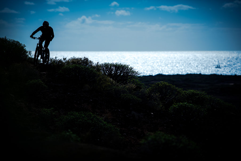 Fietser op het kustpad met zeezicht op Tenerife.