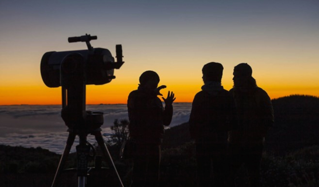 Mensen die de zonsopgang bekijken met een telescoop op Tenerife.