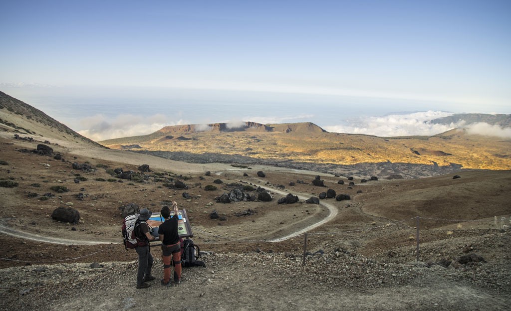 Twee mensen bekijken het landschap vanaf een uitkijkpunt op de berg Teide, Tenerife.