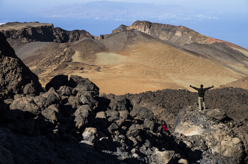 Vulkanisch landschap op de berg Teide, Tenerife, met een persoon op rotsen.