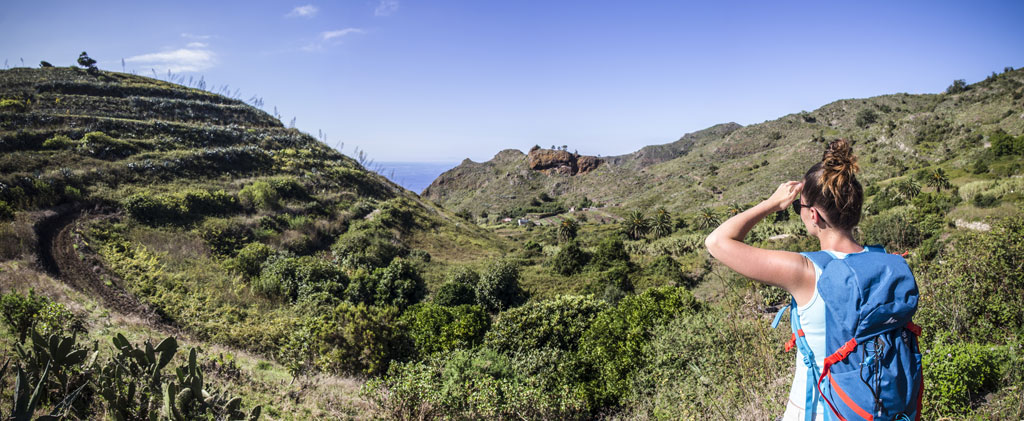 Iemand met een rugzak observeert het bergachtige landschap op Tenerife.