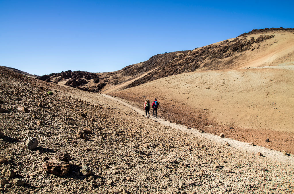 Bergpad in het Nationaal Park Teide, Tenerife, met twee mensen die lopen.