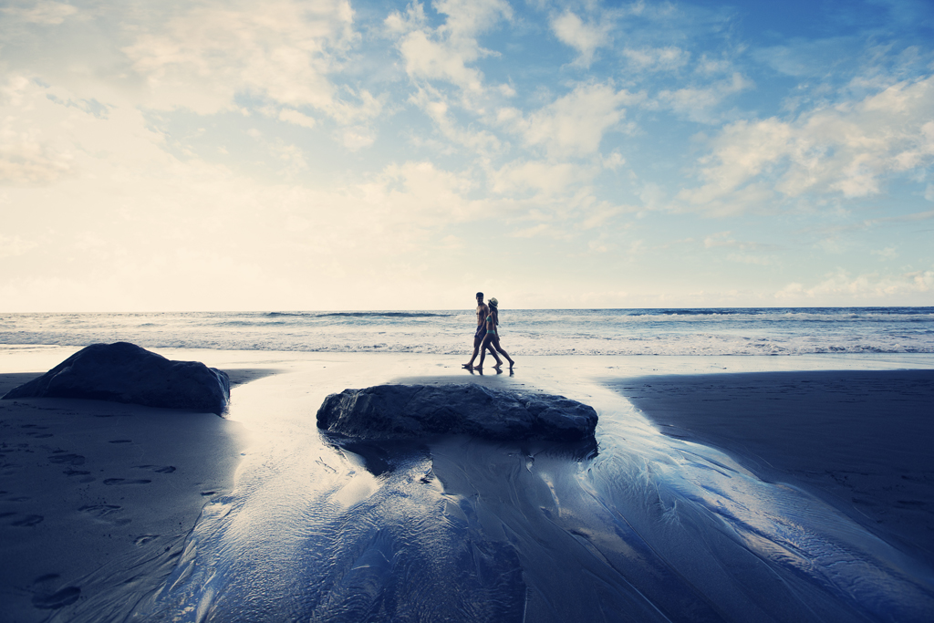 Mensen die bij zonsondergang op het strand van Tenerife wandelen.