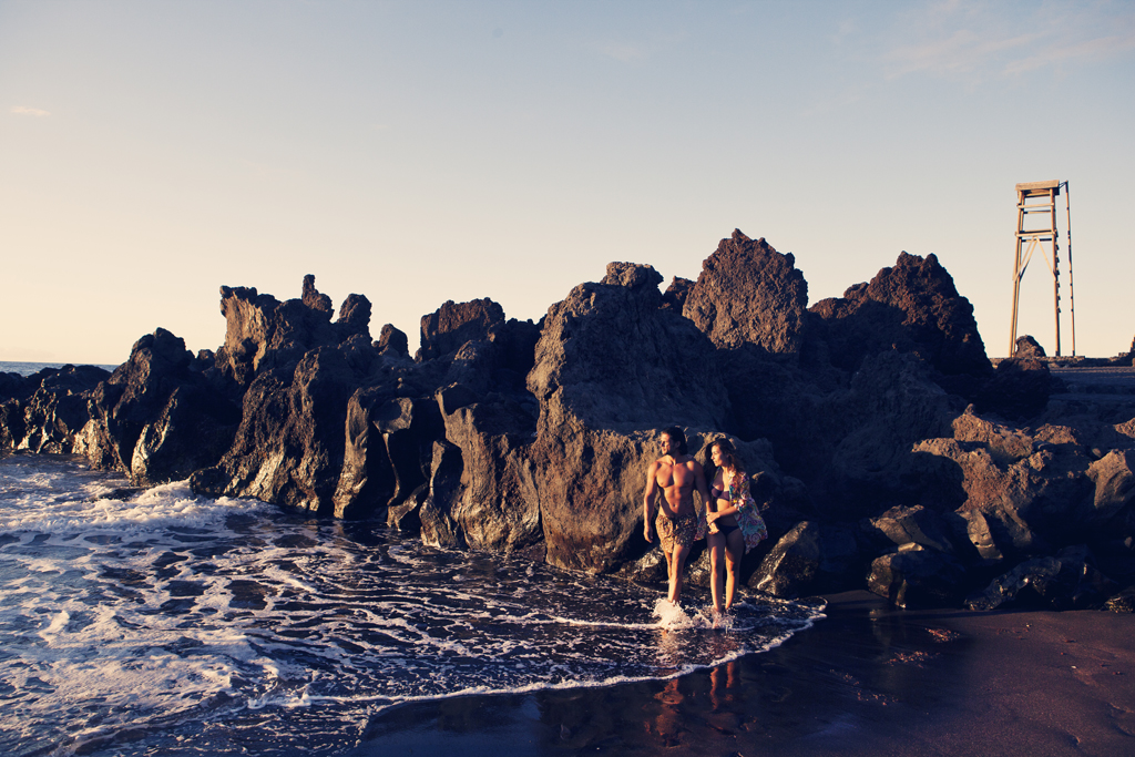 Mensen die langs het strand lopen naast rotsen in Bajamar, Tenerife.