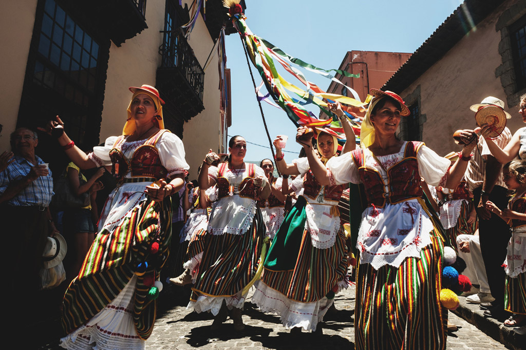 Mensen in traditionele kleding dansen op een straat op Tenerife.