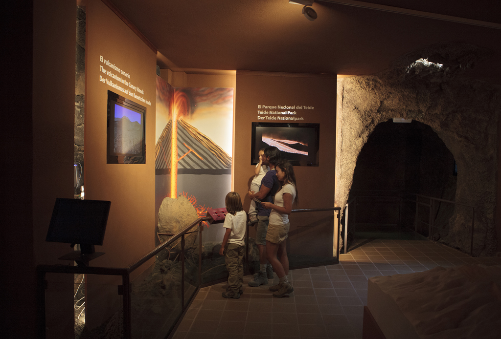Familie observeert tentoonstelling over vulkanisme in het Nationaal Park Teide, Tenerife.
