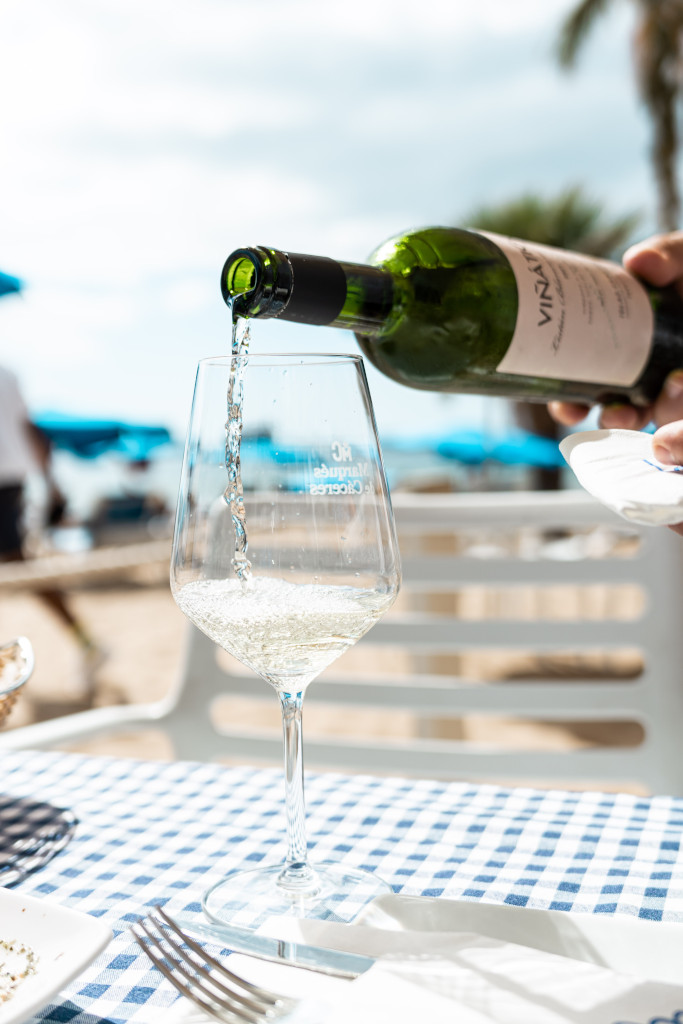 Witte wijn die wordt geserveerd in een glas op een tafel met een geruit tafelkleed op Tenerife.