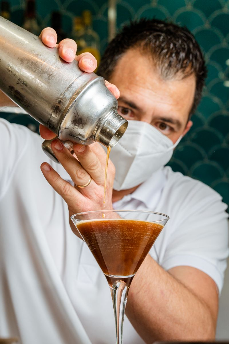 Mixoloog serveert drankje in een martiniglas op Tenerife.