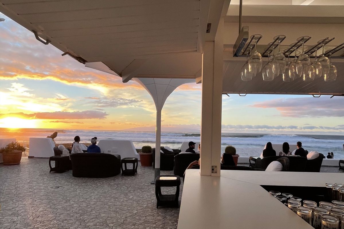 Terras op Tenerife met mensen die naar de zonsondergang boven de zee kijken.