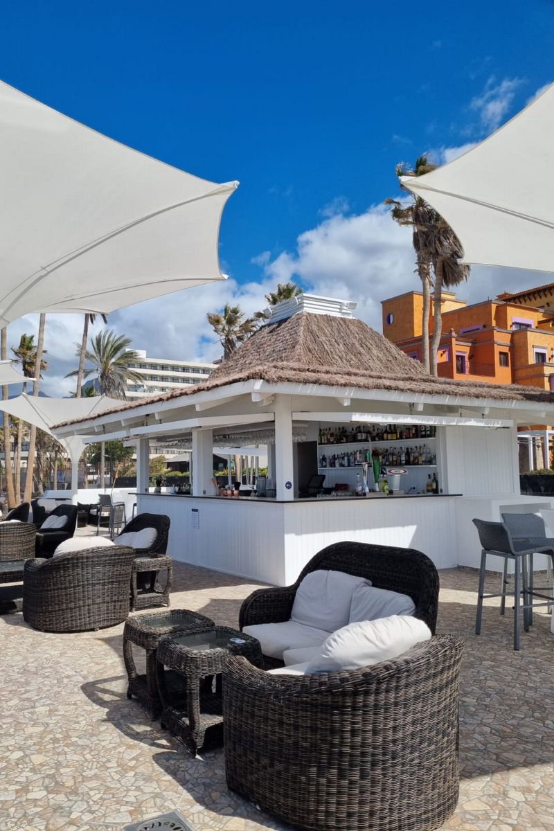 Openluchtbar met rieten dak, tafels en stoelen op Tenerife.