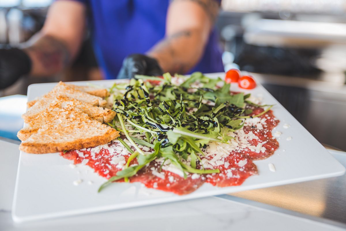 Rundercarpaccio met rucola en geroosterd brood in een restaurant op Tenerife.