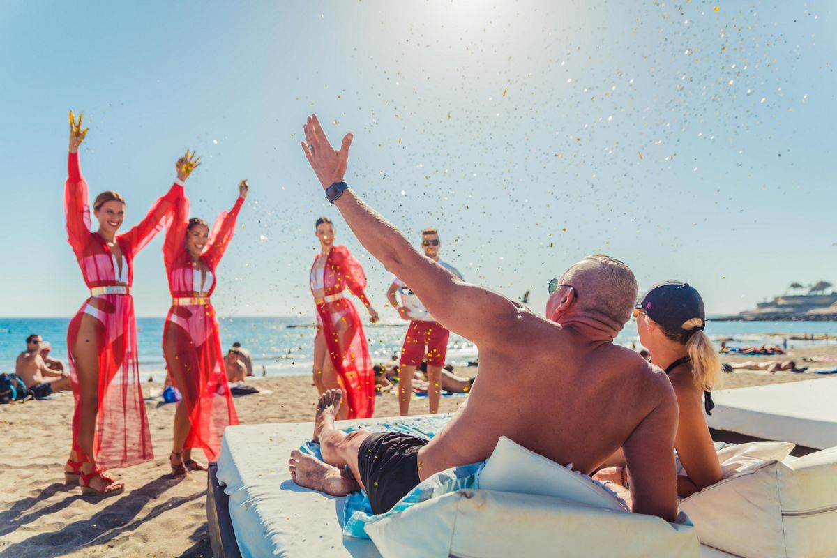 Mensen die genieten van het strand met dansers in Puerto de la Cruz, Tenerife.