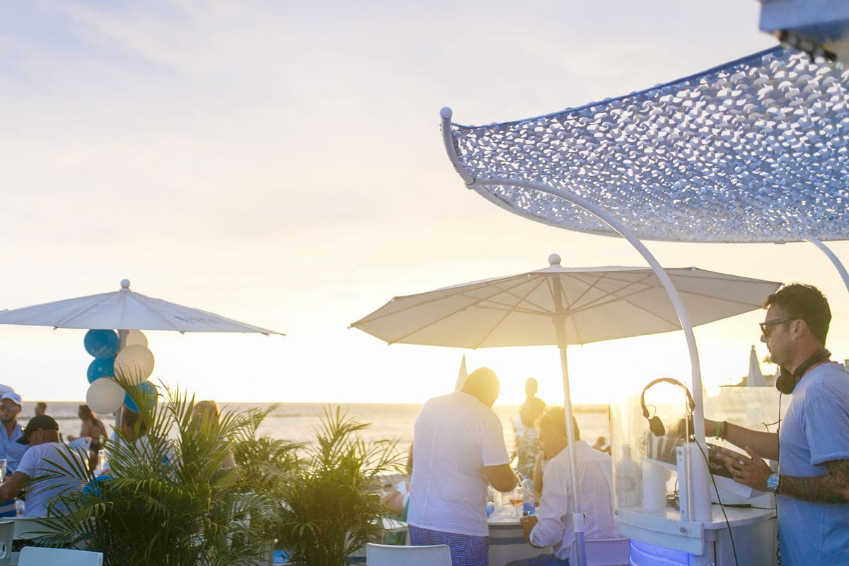 Mensen die zich vermaken op een terras aan zee op Tenerife bij zonsondergang.