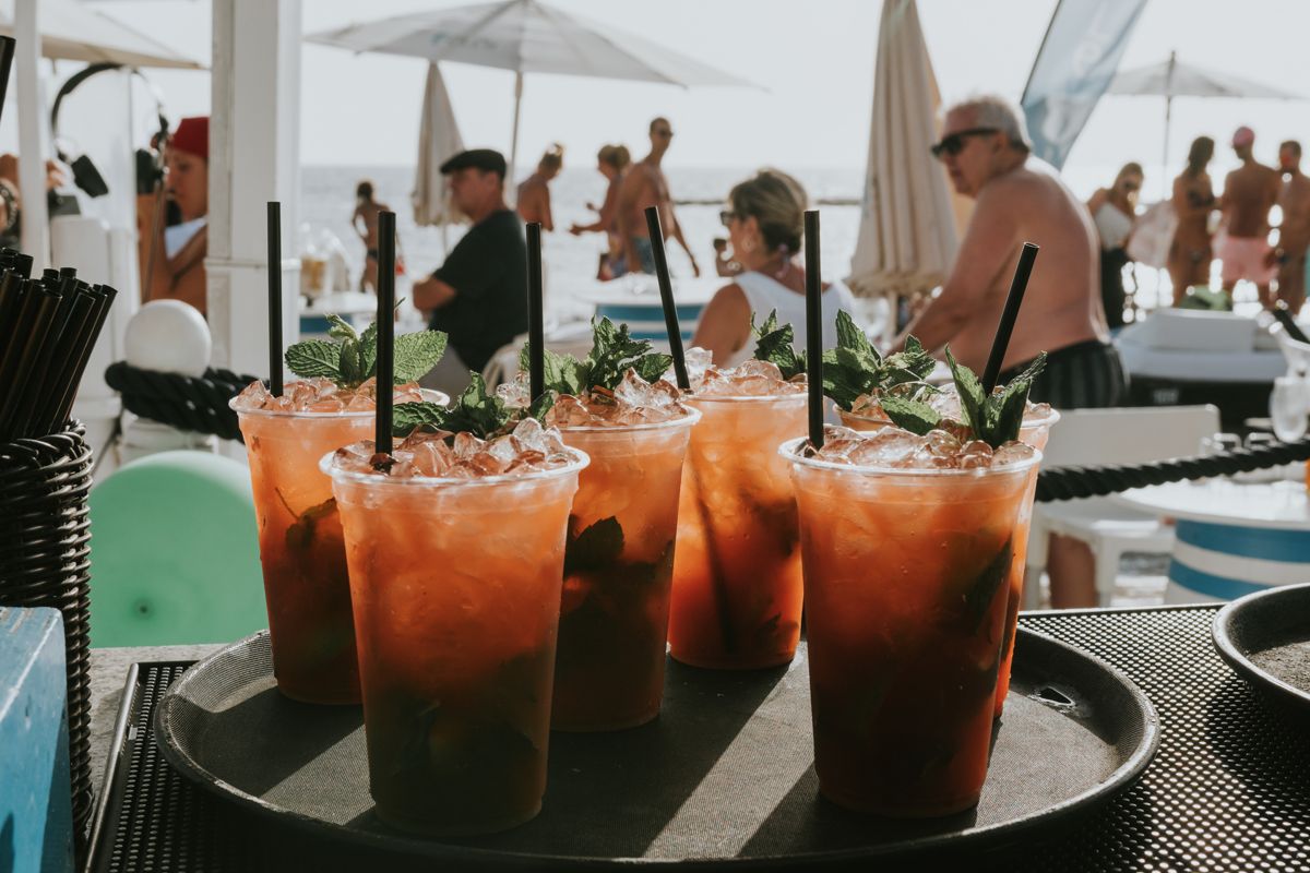 Glasen cocktails met munt en ijs op een druk strand op Tenerife.