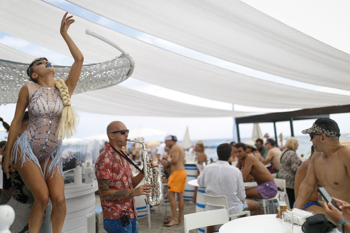 Danser en muzikant speelt saxofoon bij een buitenevenement op het strand van Tenerife.