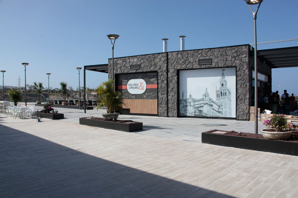 Gebouw op Tenerife met een Tex-Mex & Company-bord en muurschildering van een historisch gebouw.