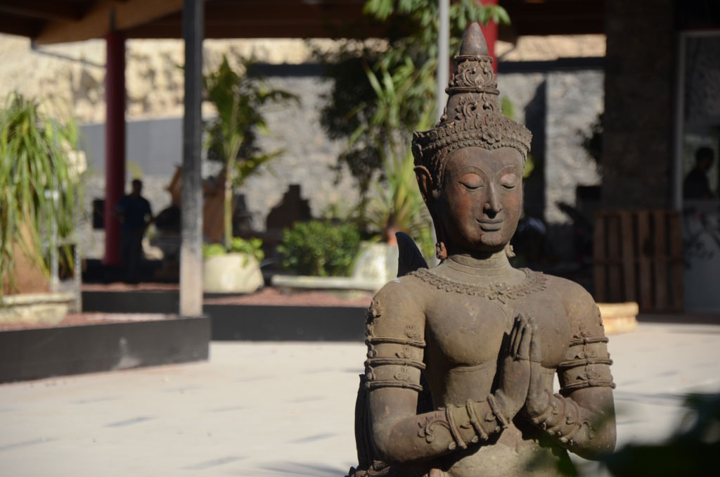 Boeddhabeeld met gevouwen handen in een tuin in Siam Park, Tenerife.