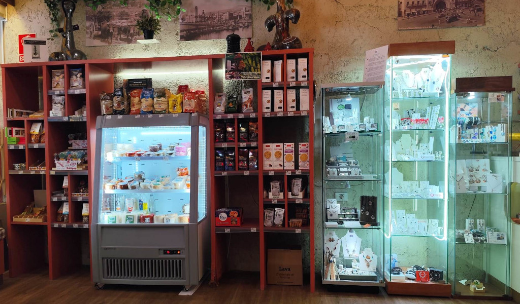 Planken met snacks, koelkast met zuivelproducten en vitrinekasten met sieraden in een winkel op Tenerife.