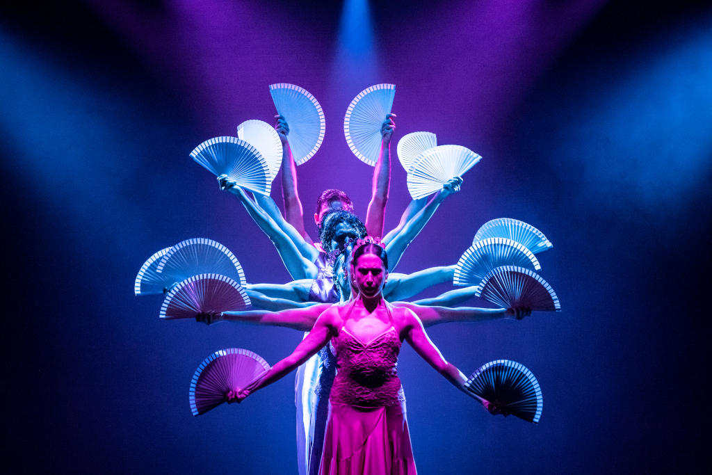 Dansers op het podium met verlichte fans bij een show op Tenerife.
