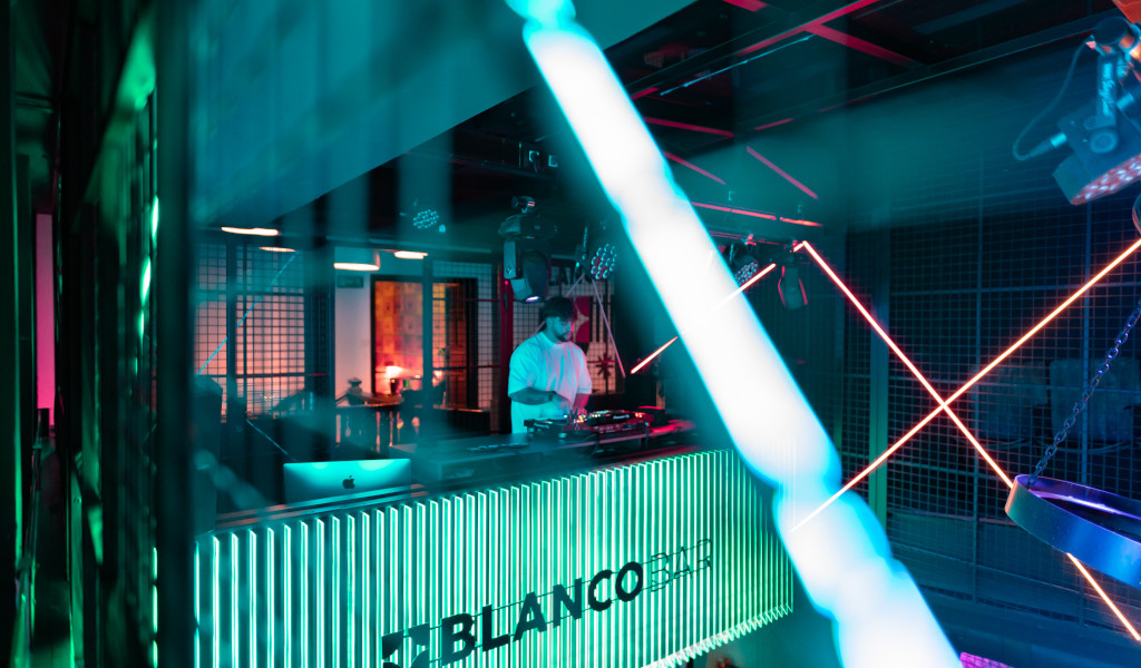 DJ draaide muziek in Blanco Bar, Tenerife, verlicht met neonlichten.