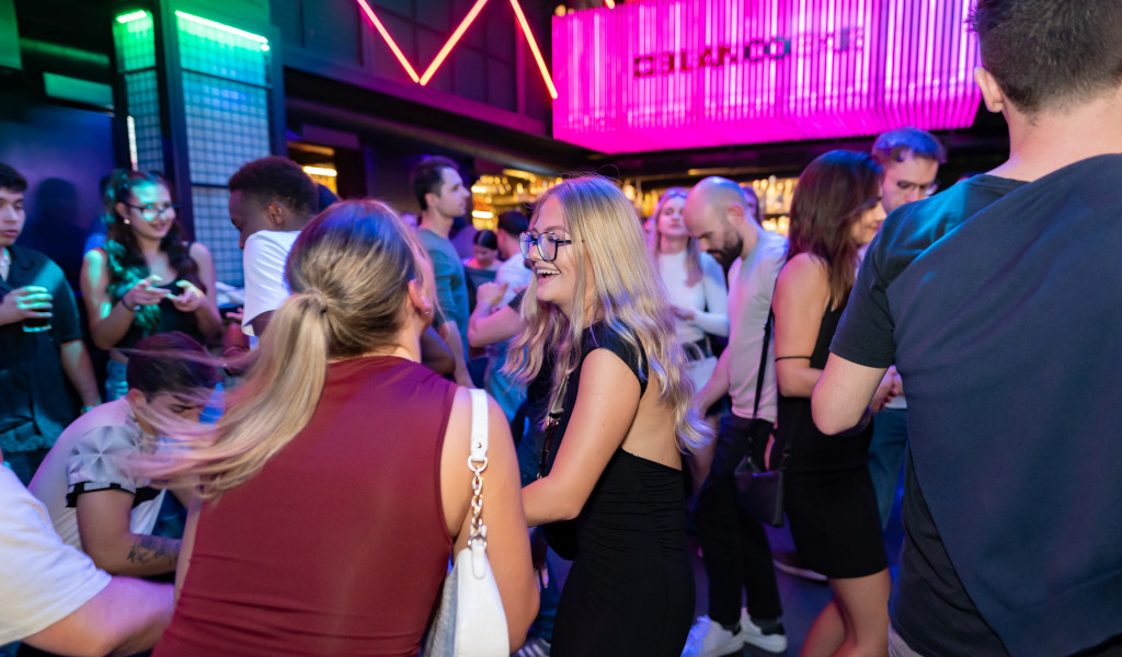 Mensen die socializen en dansen in een verlichte nachtclub op Tenerife.