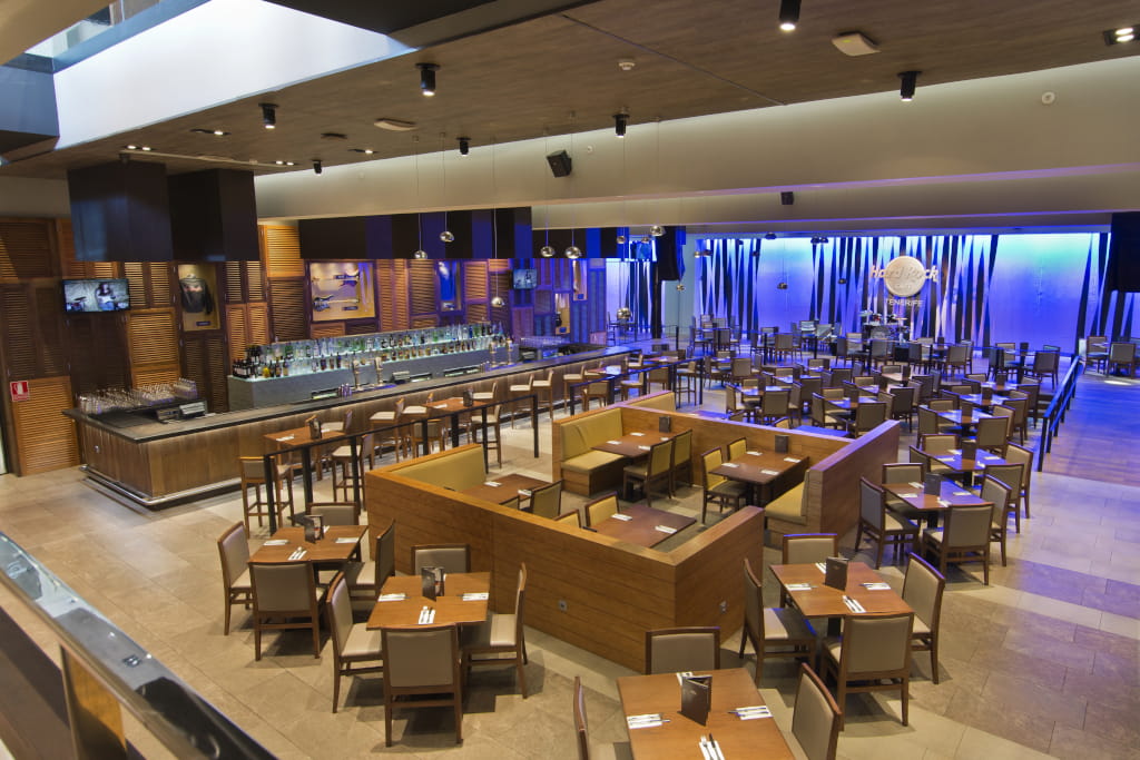 Ruim restaurant met tafels en podium achterin bij Hard Rock Tenerife.