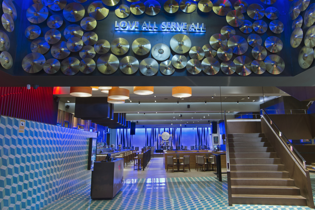 Ingang van een restaurant op Tenerife met platen en de uitdrukking Love All Serve All.