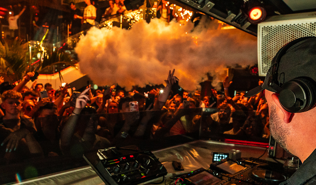 DJ die live speelt voor een levendig publiek in een club op Tenerife.
