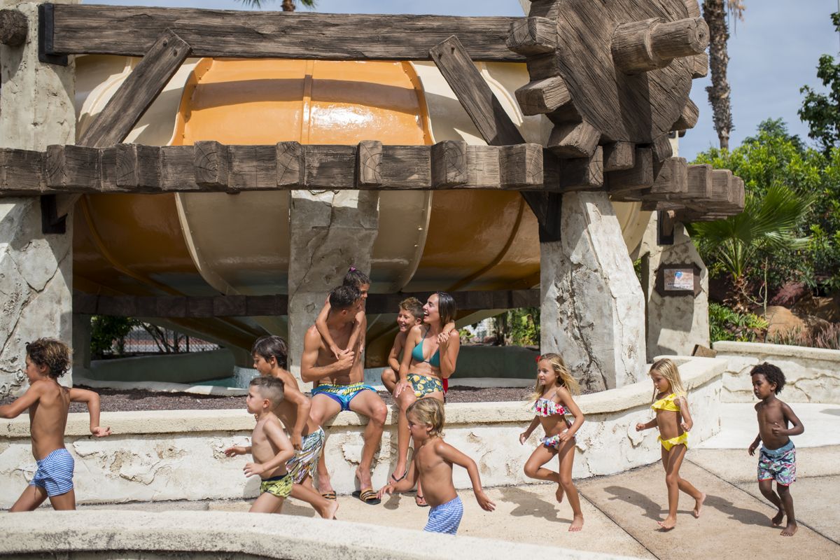 Kinderen die spelen in het waterpark op Tenerife onder een grote glijbaan.