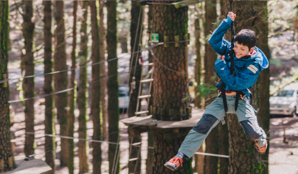 Jongen geniet van de zipline in het avonturenpark op Tenerife.