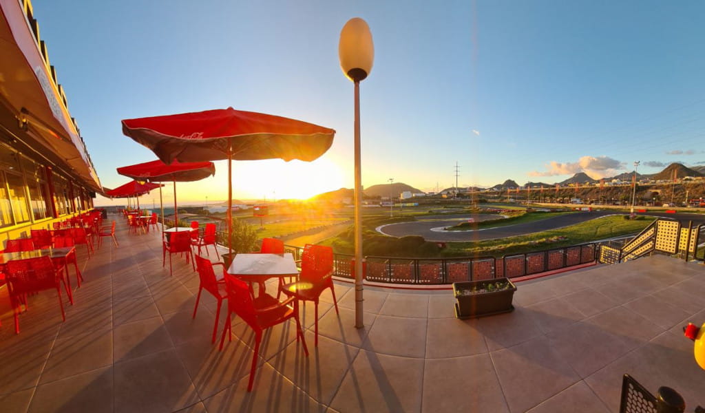 Restaurantterras met rode tafels en uitzicht op de zonsondergang op een circuit op Tenerife.