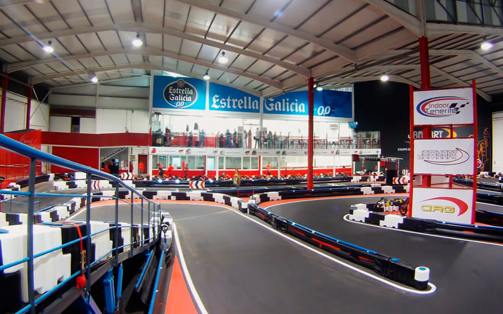 Kartbaan in Indoor Tenerife met bochten en publiek kijken.