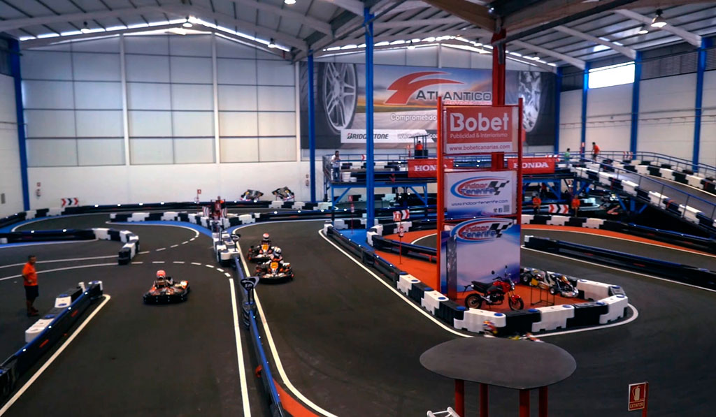 Indoor kartbaan op Tenerife met karts in de race en een Bobet-bord.