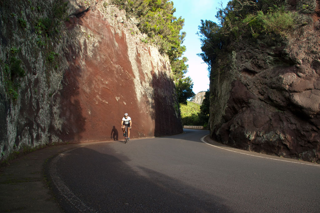 Fietser op de weg omringd door rotsformaties op Tenerife.