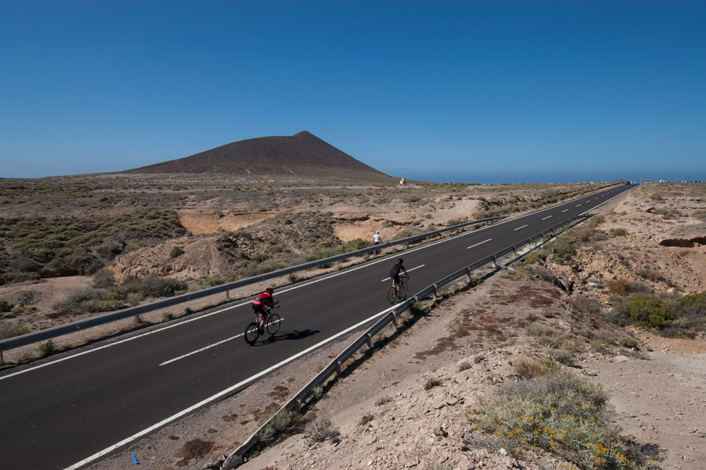 Fietsers op de weg naar de bergen op Tenerife onder heldere lucht.