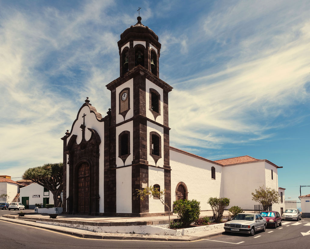 Kerk in Garachico, Tenerife, met heldere luchten en bomen overal.