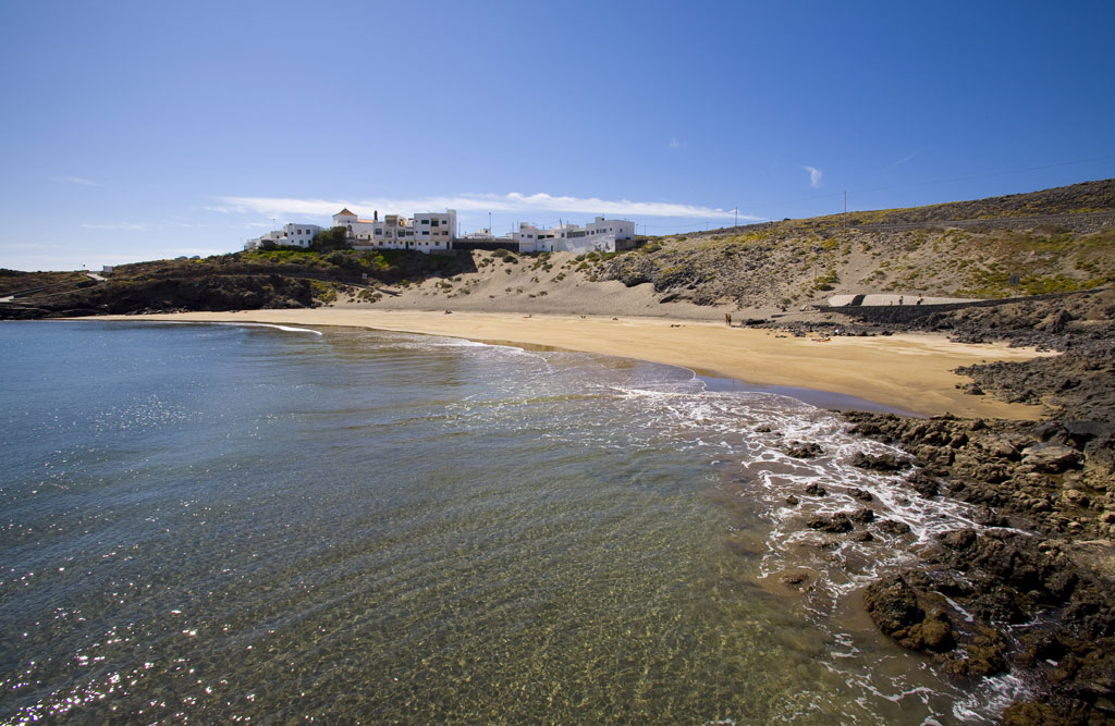 Strand met gouden zand en gebouwen op de achtergrond aan de kust van Tenerife.