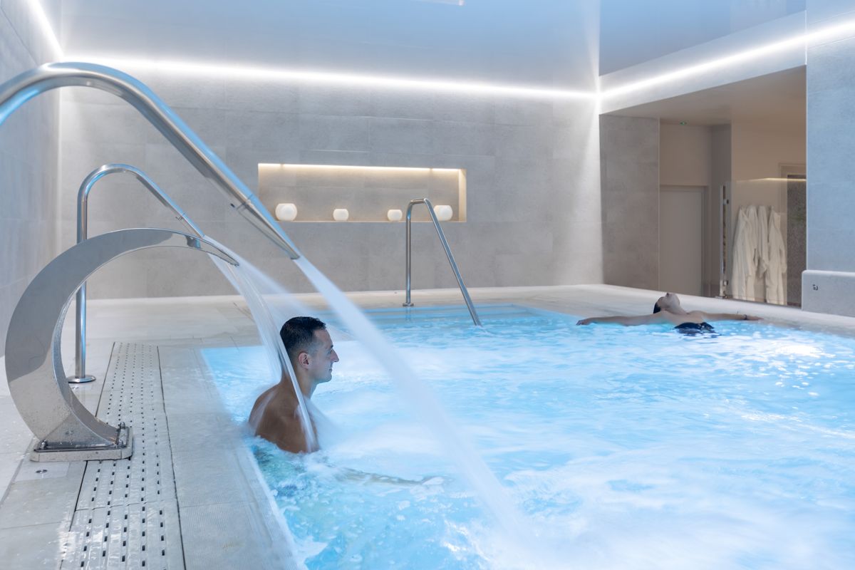 Man geniet van een binnenzwembad met waterstraal in de spa van Tenerife.