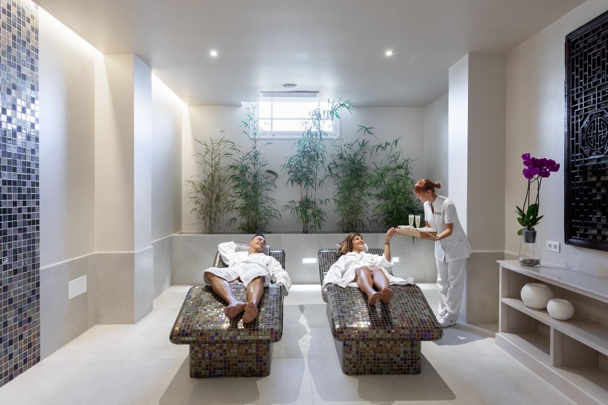 Mensen die ontspannen in een spa op Tenerife met een glas drankje.
