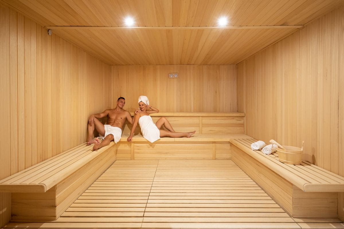 Mensen die ontspannen in een houten sauna met handdoeken op Tenerife.