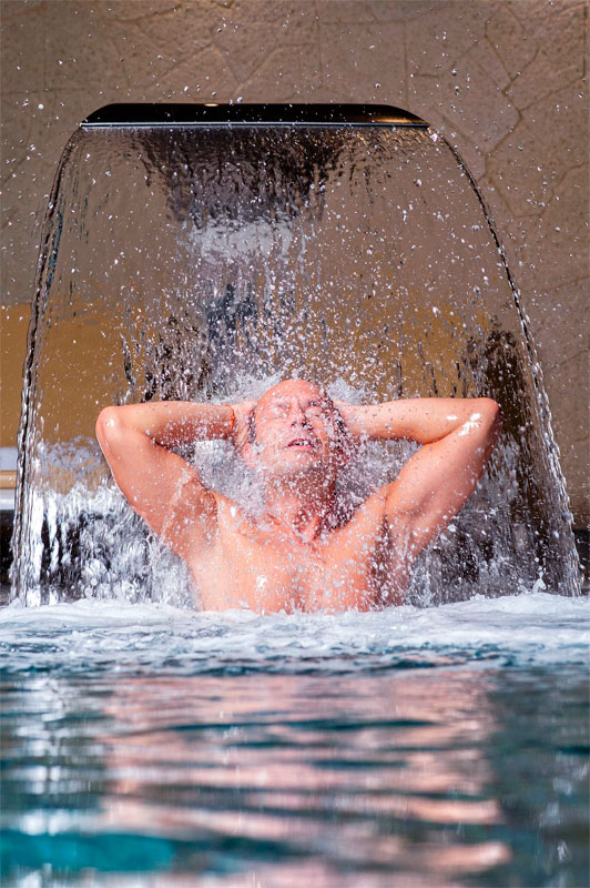 Persoon onder waterval in het kuuroord op Tenerife.