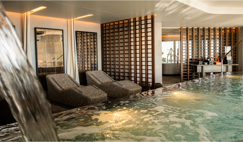 Binnenzwembad met ontspanningsligstoelen en decoratieve wanden op Tenerife.
