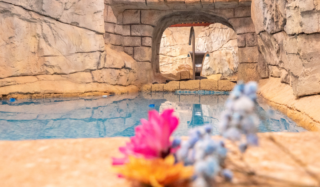 Binnenzwembad met rotswanden en bloemen eraan op Tenerife.