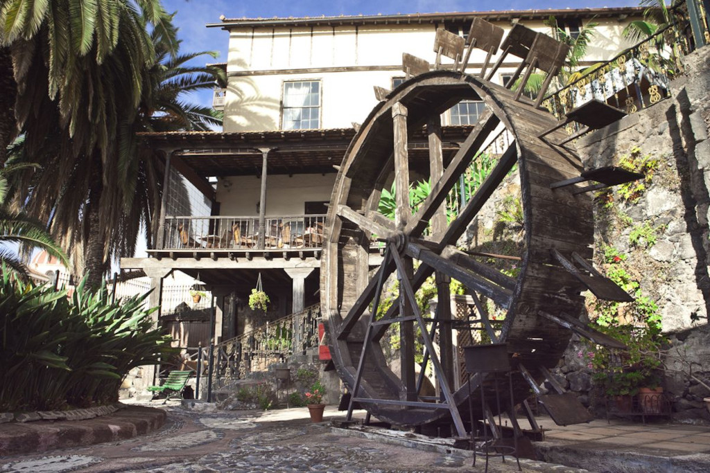 Oude watermolen in La Orotava, omgeven door vegetatie en klassieke architectuur.